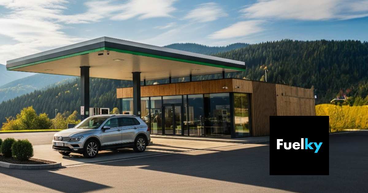 Ilustračný obrázok: auto na ceste s jesennými farbami a čerpacia stanica v pozadí